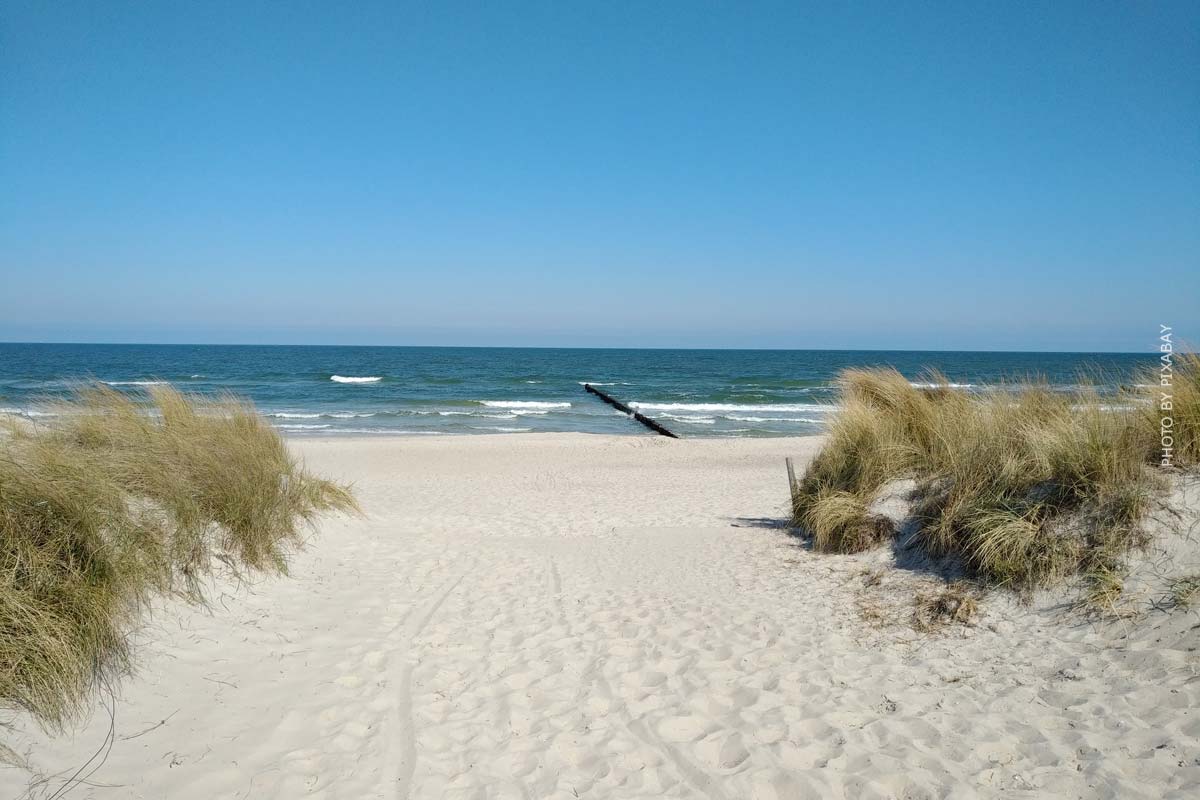 En sandsti fører til stranden og havet