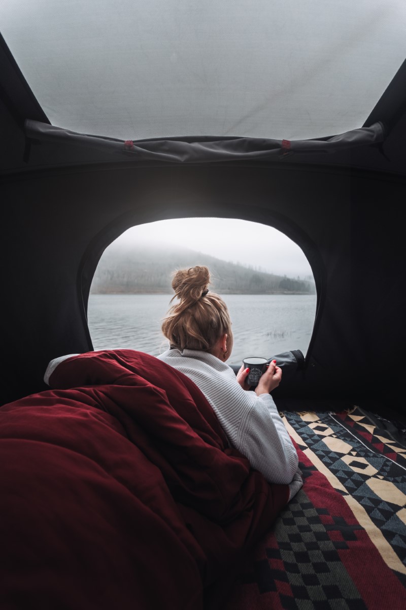 Kvinde nyder en kop te i tagtelt på T6