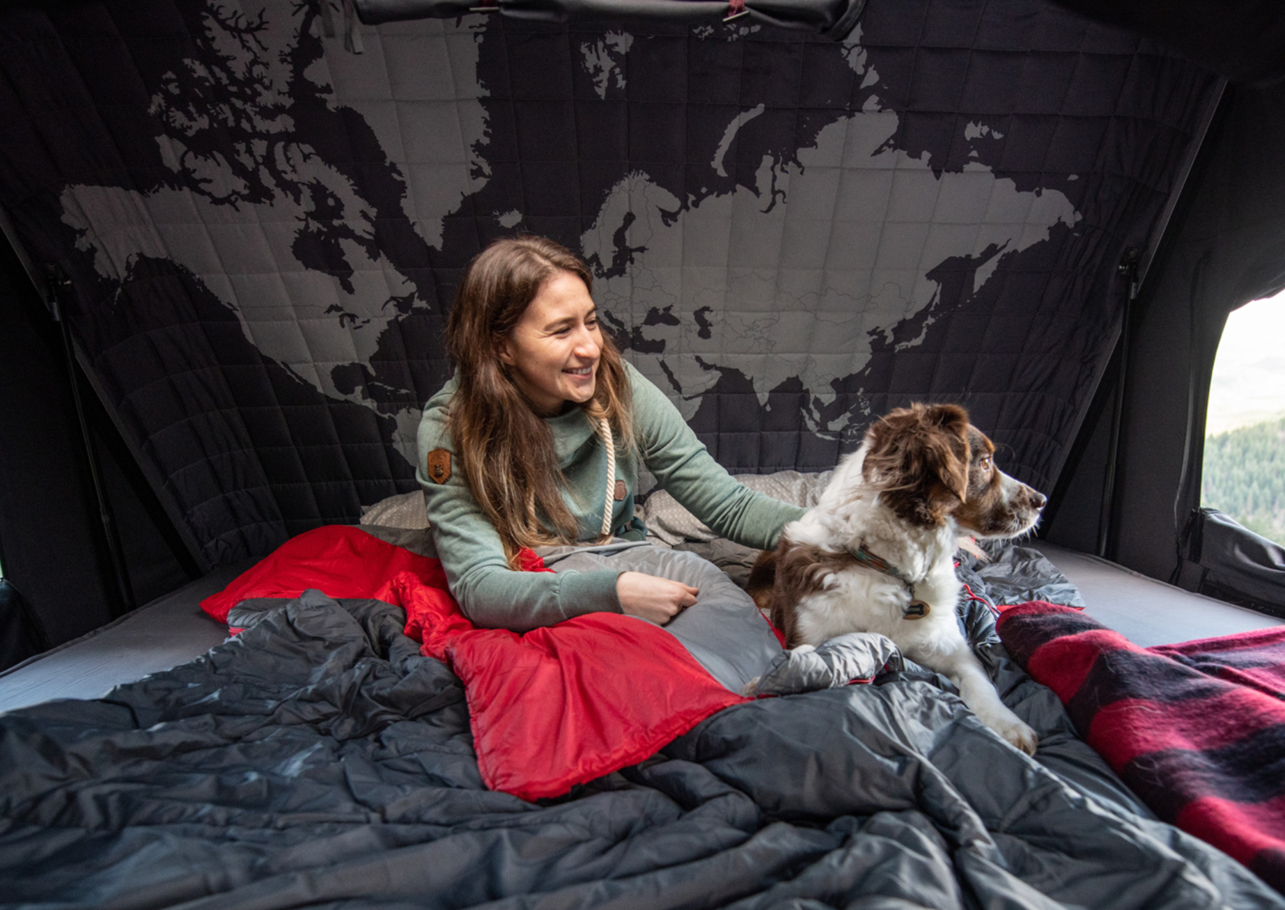 Kvinde sidder med sin hund i et hard shell-tagtelt til 1 person